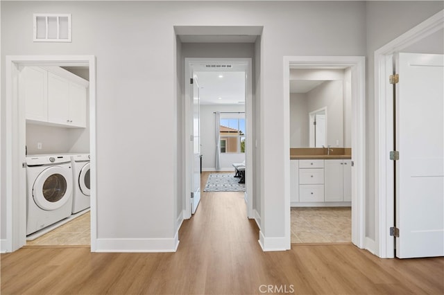149 Fairgreen, Irvine, CA 92618 - clothes washing area featuring washer and clothes dryer, light wood finished floors, baseboards, and cabinet space