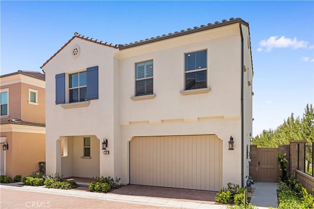 149 Fairgreen, Irvine, CA 92618 - view of front facade with stucco siding, an attached garage, fence, a gate, and decorative driveway