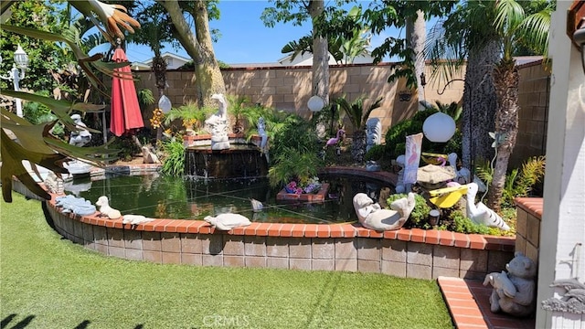 fenced backyard with a garden pond