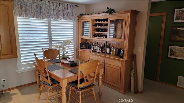 dining space with a dry bar and baseboards