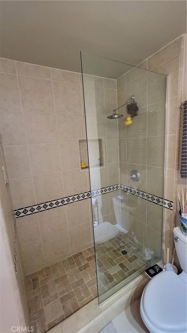 bathroom featuring toilet and tiled shower