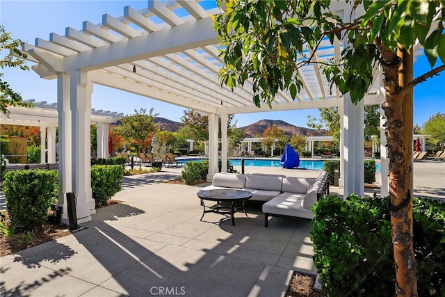 view of patio / terrace with a pergola, a mountain view, and a community pool
