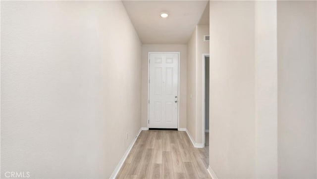 hall featuring baseboards and light wood-style flooring