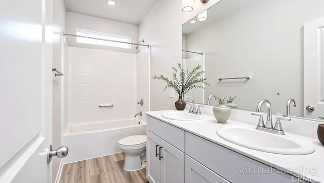 full bathroom with toilet, double vanity, wood finished floors, and  shower combination