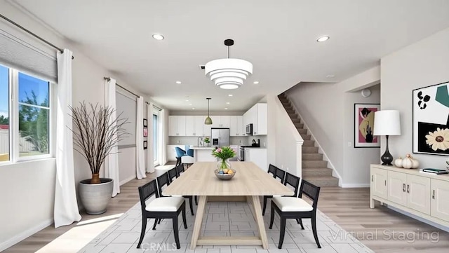 dining area with baseboards, light wood-type flooring, recessed lighting, and stairway