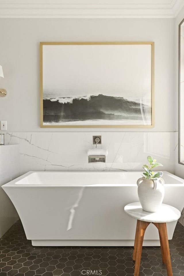bathroom with crown molding, tile walls, a wainscoted wall, and a freestanding tub