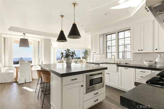 kitchen featuring dark countertops, plenty of natural light, tasteful backsplash, and a sink
