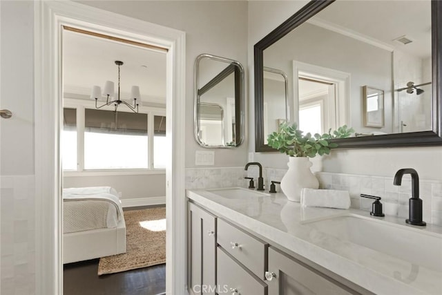 full bathroom featuring a healthy amount of sunlight, ensuite bath, and a sink