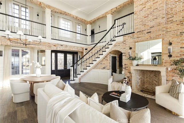 living room with a wealth of natural light, wood finished floors, and a high ceiling