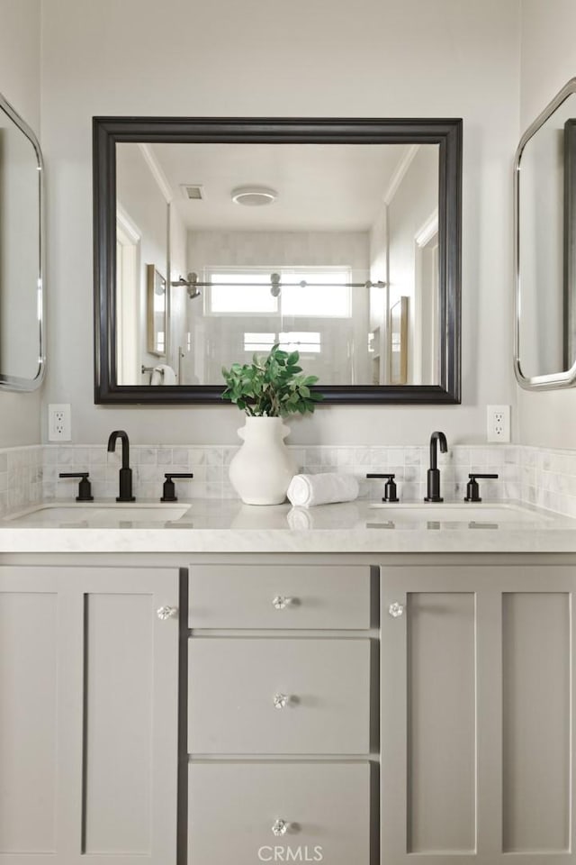 full bathroom with double vanity, visible vents, and a sink