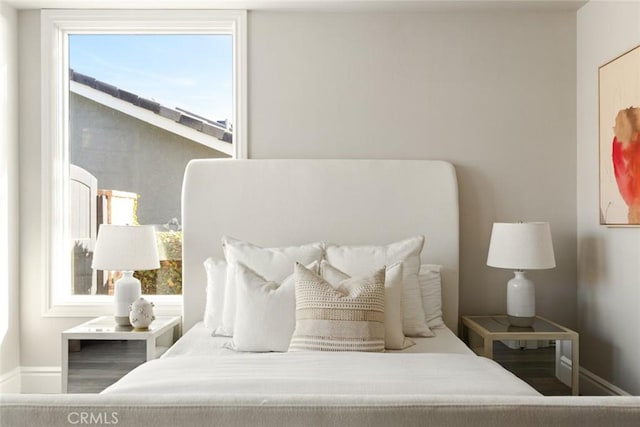 bedroom with baseboards and wood finished floors
