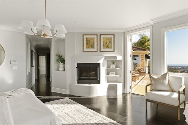 interior space with wood finished floors, baseboards, ornamental molding, and a glass covered fireplace