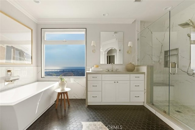 bathroom featuring a freestanding bath, ornamental molding, a marble finish shower, and vanity