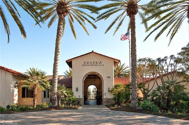 94 Paseo Vis, San Clemente, CA 92673 - view of front facade featuring stone siding, a tiled roof, stucco siding, and a gate