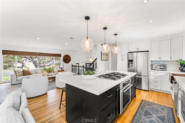 13402 Wheeler, North Tustin, CA 92705 - kitchen featuring white cabinetry, dark cabinets, open floor plan, and appliances with stainless steel finishes