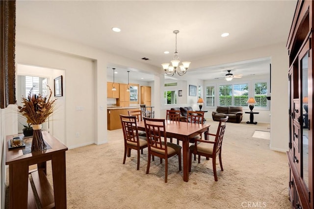 dining space featuring light carpet, visible vents, recessed lighting, and ceiling fan with notable chandelier