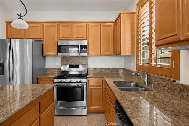 kitchen featuring a sink, stone countertops, stainless steel appliances, light tile patterned floors, and hanging light fixtures