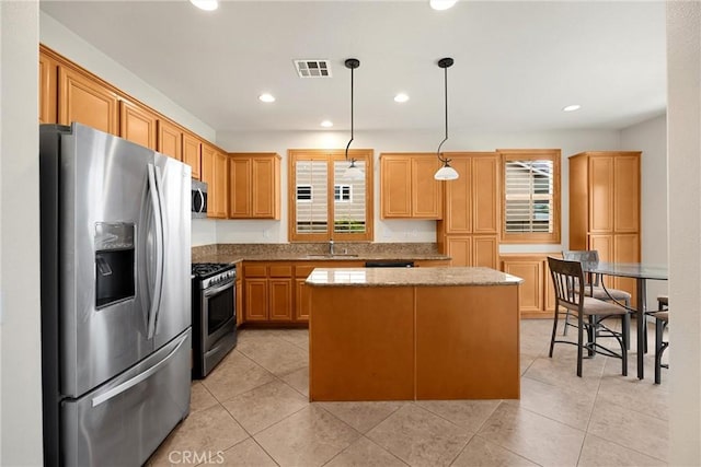 kitchen featuring visible vents, a kitchen island, a healthy amount of sunlight, and appliances with stainless steel finishes