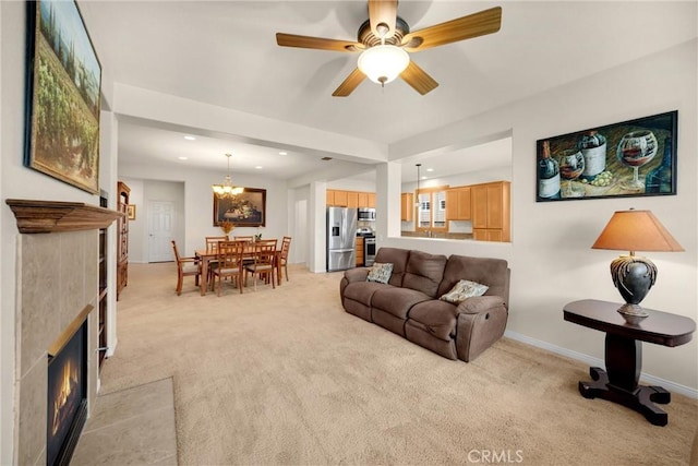 living area featuring ceiling fan with notable chandelier, light colored carpet, recessed lighting, baseboards, and a tiled fireplace