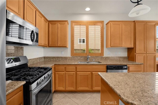 kitchen with a sink, light stone countertops, appliances with stainless steel finishes, light tile patterned flooring, and recessed lighting