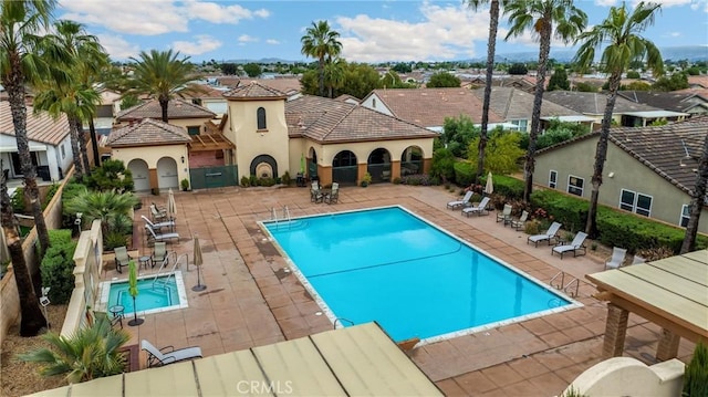 community pool with a patio, a residential view, and fence