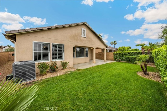 back of property with central air condition unit, a yard, a patio, stucco siding, and a fenced backyard