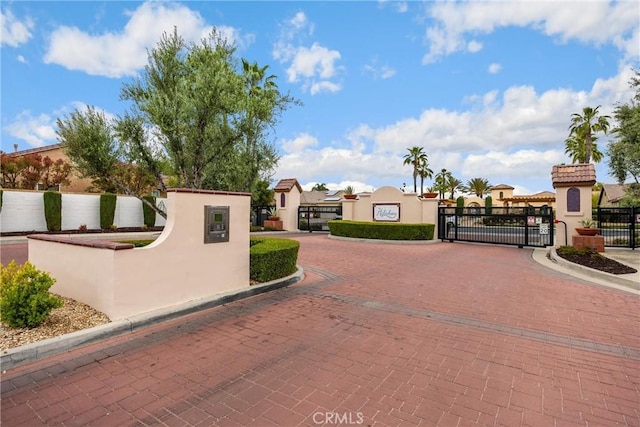 view of road with curbs, a gated entry, and a gate