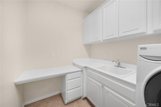 clothes washing area featuring light tile patterned floors, a sink, cabinet space, baseboards, and washer / clothes dryer