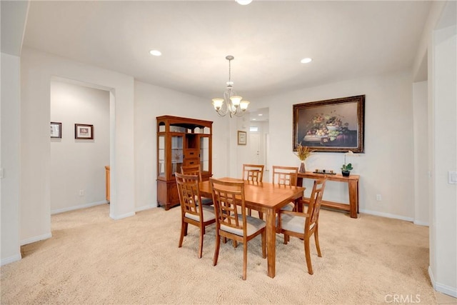 dining space with baseboards, light carpet, an inviting chandelier, and recessed lighting
