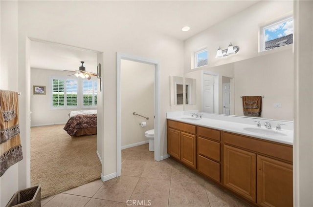 full bathroom with double vanity, toilet, ensuite bathroom, and a sink
