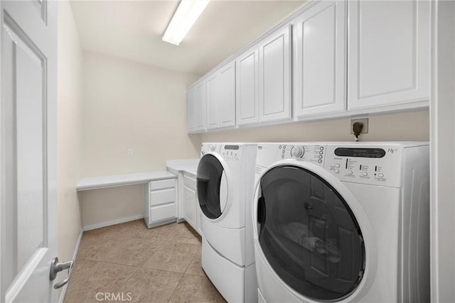 washroom with washing machine and clothes dryer, baseboards, light tile patterned flooring, and cabinet space