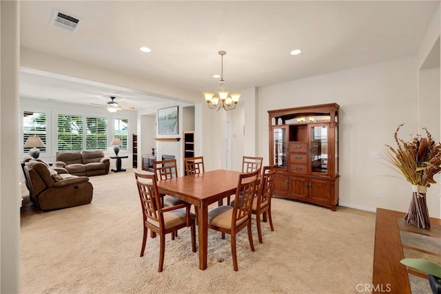 dining room featuring light carpet, ceiling fan with notable chandelier, visible vents, and recessed lighting