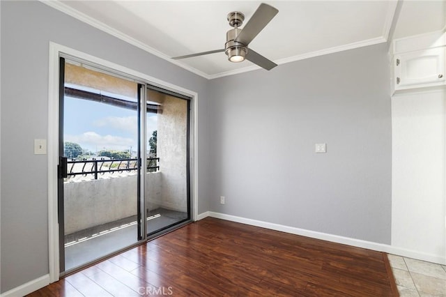 spare room with a ceiling fan, ornamental molding, wood finished floors, and baseboards