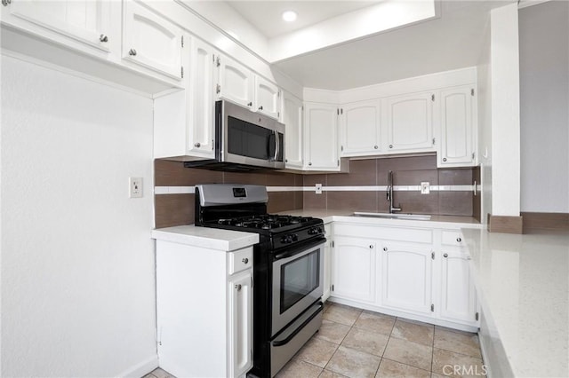 kitchen featuring white cabinetry, decorative backsplash, stainless steel appliances, and a sink