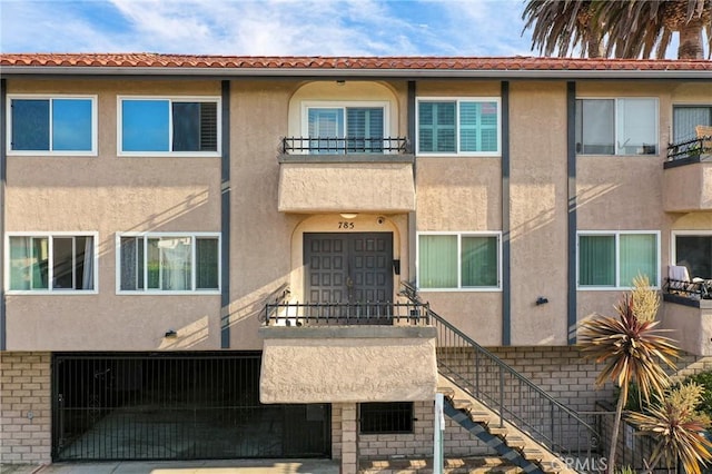 785 W 19th St Unit 10, San Pedro, CA 90731 - view of front of house with stucco siding, a balcony, and stairway