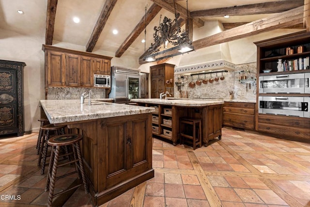3325 Figueroa Mountain Rd, Los Olivos, CA 93441 - kitchen featuring open shelves, built in appliances, an island with sink, backsplash, and light stone counters