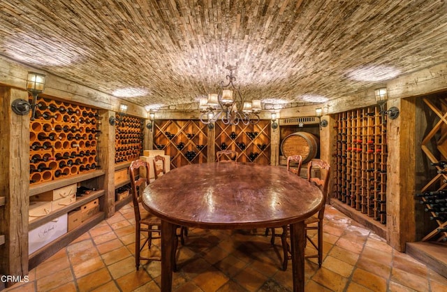 3325 Figueroa Mountain Rd, Los Olivos, CA 93441 - wine area with stone tile flooring, a chandelier, and wooden walls