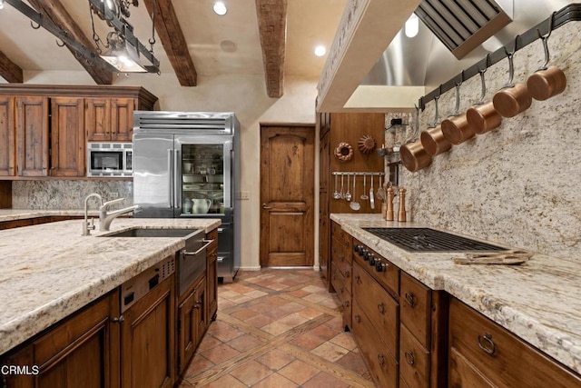 3325 Figueroa Mountain Rd, Los Olivos, CA 93441 - kitchen featuring built in appliances, beam ceiling, tasteful backsplash, inlaid floor details, and light stone countertops