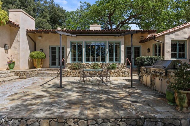 3325 Figueroa Mountain Rd, Los Olivos, CA 93441 - back of house with french doors, a chimney, a patio, an outdoor kitchen, and stucco siding