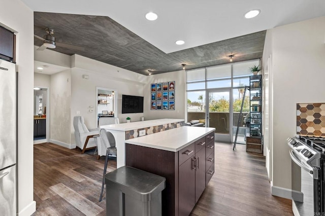 kitchen with gas stove, open floor plan, light countertops, and dark wood finished floors