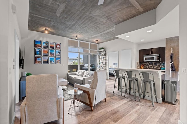living area featuring light wood finished floors and recessed lighting