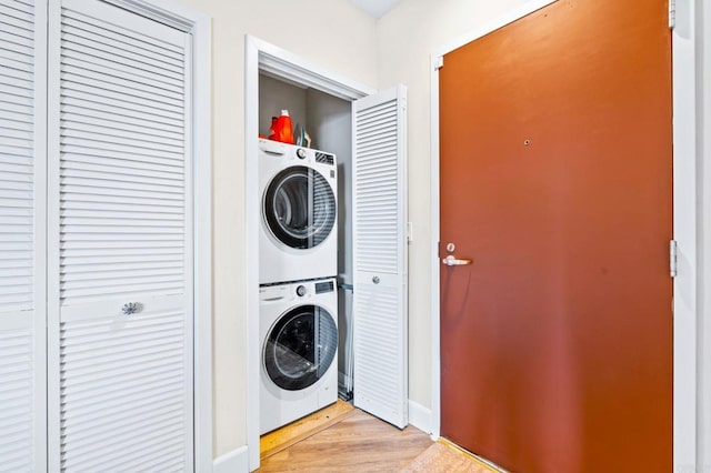 3740 Park Blvd Unit 209, San Diego, CA 92103 - laundry area featuring stacked washer and clothes dryer, light wood-type flooring, and baseboards