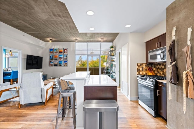 3740 Park Blvd Unit 209, San Diego, CA 92103 - kitchen with stainless steel appliances, light wood finished floors, light countertops, a kitchen breakfast bar, and recessed lighting