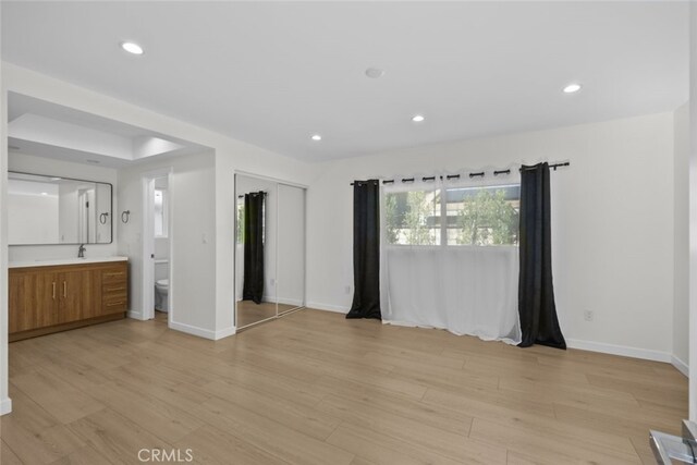 24431 La Glorita Cir, Newhall, CA 91321 - unfurnished bedroom featuring a sink, recessed lighting, light wood-style flooring, connected bathroom, and baseboards