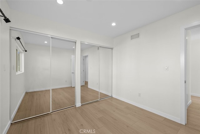 24431 La Glorita Cir, Newhall, CA 91321 - unfurnished bedroom featuring light wood-style flooring, multiple closets, visible vents, baseboards, and recessed lighting