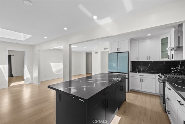 24431 La Glorita Cir, Newhall, CA 91321 - kitchen with built in refrigerator, stainless steel gas range oven, white cabinets, and a skylight