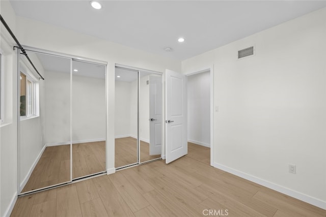 24431 La Glorita Cir, Newhall, CA 91321 - unfurnished bedroom featuring light wood-type flooring, visible vents, recessed lighting, two closets, and baseboards