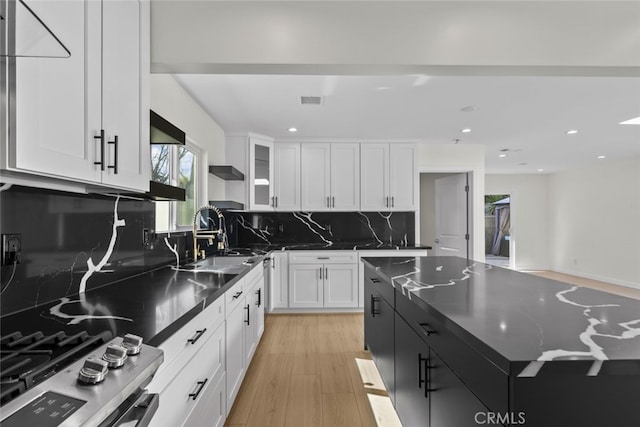 24431 La Glorita Cir, Newhall, CA 91321 - kitchen featuring white cabinets, decorative backsplash, stainless steel gas stove, and a sink
