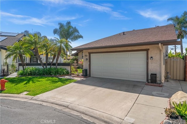 ranch-style home with a gate, stucco siding, fence, a front lawn, and driveway