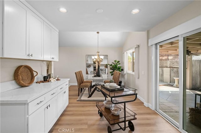 dining area with baseboards, a notable chandelier, recessed lighting, and light wood-style floors